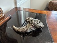 Left side view of Brunel metal cornucopia on black surface