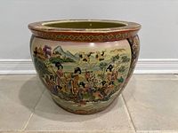 Front view of porcelain fish bowl planter showing exterior painted scene