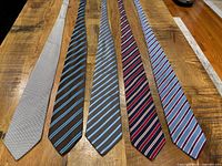 Five ties laid flat front view showing patterns