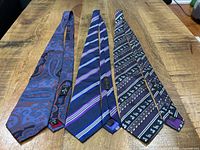 Three Etro silk ties laid full length showing patterns and labels