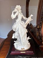 Front view of Giuseppe Armani figurine with amphora on wooden base