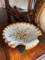 Angled view of porcelain clamshell dish on dresser