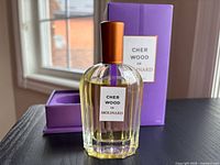 Front view of bottle in open box alongside outer box