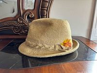 Overall view of tan fur felt fedora with feather accent