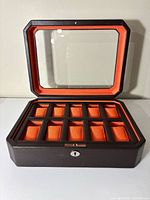 Open watch box showing orange interior and 10 compartments