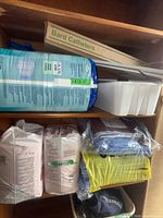 Shelf with briefs pack, Bard Catheters box, reacher, bins, underpad packs