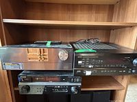 Three AV receivers stacked on shelving: Samsung, Denon AVR-1801, Pioneer VSX-918V