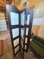 Three of the hinged dark brown panels showing multiple photo frame openings