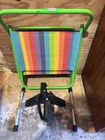 Folding stool with rainbow stripe seat and pedal exerciser below