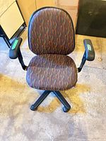 Front view of patterned fabric office chair showing seat, backrest, arms, and base