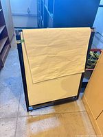 Front view of folded flip chart easel showing whiteboard and attached paper pad
