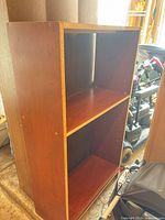 Full view of cherry laminate bookcase showing two shelf compartments and adjustable pin holes