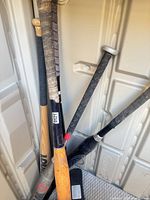 Group of mixed bats leaning in storage shed