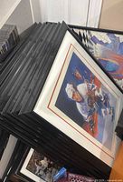 Stack of framed NHL prints showing black frames and hockey artwork