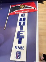 Flag and Quiet Please sign laid on surface