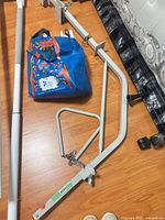 Complete trapeze rail with triangular handle, clamps, chain hardware on wood floor