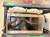 Front view of Panasonic microwave with Salton hot plate resting on top