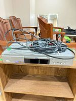 Front view of Samsung DVD-S222 player with bundled cables on top