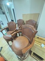 Four wood and leather bar stools grouped together
