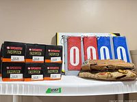 Group shot showing Worth Fastpitch boxes, flip scoreboard, stacked tan gloves on shelf