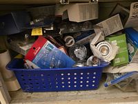 Blue basket and shelf filled with assorted packaged and loose light bulbs