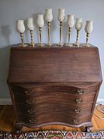 Full view of desk front with all eight candlesticks arranged on top