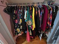 Full clothing rack showing large quantity of assorted patterned women’s garments