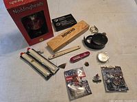 Overview showing bobblehead box, domino set, Swiss Army knife, compass, pocket watch, flares, pins and accessories