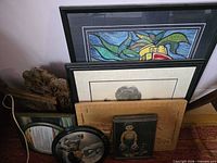 Group of framed items stacked, showing variety and materials
