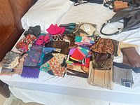 Overview of all scarves, shawls and fur collars laid out on bed