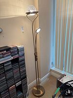 Full view of torchiere floor lamp beside CD rack