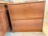 Front/side view of brown walnut laminate 2-drawer filing cabinet