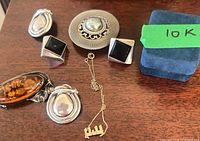 All jewelry pieces laid out on wood surface with Birks box visible