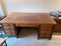 Front view of oak executive pedestal desk showing top surface and drawer layout