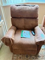 Front view of recliner with remote and manual on seat