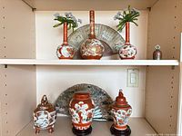 Overall view of porcelain vases, ginger jar, fans, stems and stands on shelves