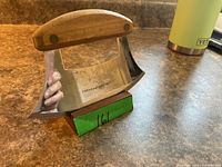 Ulu knife on wooden stand, full view