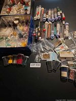 Overall lot view showing storage box, vials of beads, packets of findings
