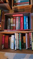 Two boxes filled with assorted books, spines outward