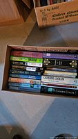 Box of books showing titles Orr: My Story, Twisted, James Patterson, Walking and others