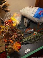 Overview of lot with stuffing bag, wire spool, cups, foliage, tool