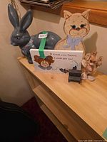 Group shot showing ceramic rabbit, wooden cat, wooden sign, mini bench, raffia angel