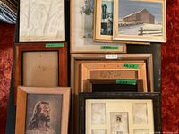 Assorted framed art prints and stacked empty frames