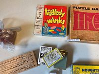 Overview with Tiddledy Winks, Hi-Q box, cribbage board, cards, pegs, edge of Noughts & Crosses