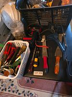 Overview of table with drill, trowels, basket of tools, helmets and hardware