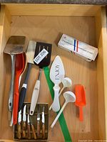 Drawer view showing spatulas, steak knives, sharpening stones box and other utensils