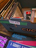 Box filled with assorted music books and sheet music, front items include Music Staff Book and 40 Classic Hits