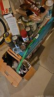 Overview of assorted paint cans, spray paint, filler box, roller set carton