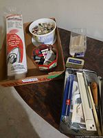 Overall lot showing HeatnBond roll, button container, octagonal tin, additional tins and tools