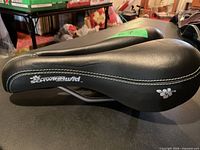 Side view of Schwinn black bicycle saddle with floral logo
